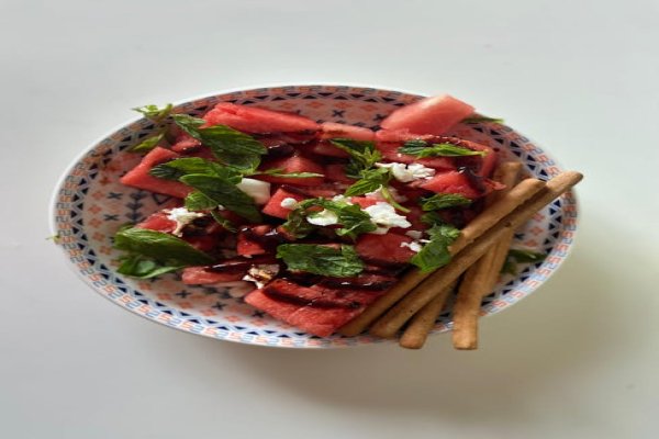 A bowl of grilled watermelon salad with feta and mint.