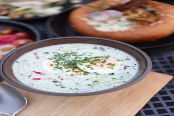 Bowl of creamy summer corn chowder garnished with chives.