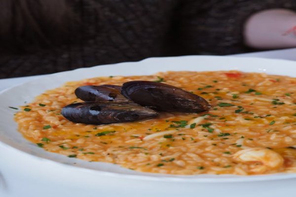 Creamy artichoke risotto in a bowl, garnished with parsley.